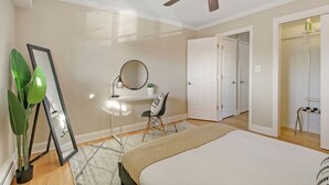 A bedroom with a bed, a desk, a chair, a mirror, a ceiling fan, and a potted plant. - Sunny 1BR Apt in Suburb - Salem 3C rep (Arlington Heights)