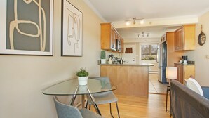A modern kitchen with wooden cabinets, a glass dining table, and a potted plant. - Sunny 1BR Apt in Suburb - Salem 3C rep (Arlington Heights)