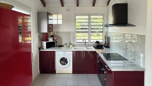 A kitchen with a washing machine, a microwave, and a sink. - Maison Sainte-anne (Sainte-Anne)
