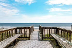 A wooden boardwalk leading to a beach with a clear view of the ocean. - Breakers | Oceanfront (Nags Head)