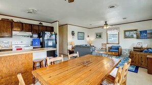A spacious kitchen with wooden cabinets, a dining table, and a living area with a sofa and chairs.