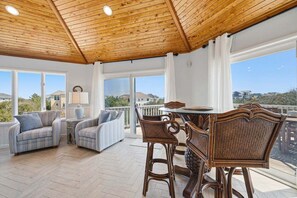A spacious balcony with wicker furniture and a view of the surrounding landscape.