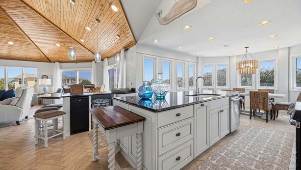 A spacious kitchen with a large island, wooden ceiling, and large windows. - Tide Together | 880 ft to the beach (Corolla)