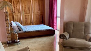 A room with a bed, two sofas, a lamp, and wooden cabinets. - Comfortable apartment in the center of Gueliz, close to all amenities. (Marrakech)