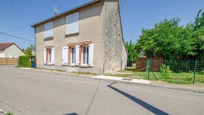 A two-story building with a stone facade, multiple windows with shutters, and a paved road in front. - La Maison d'à côté - CRANCEY (CRANCEY)