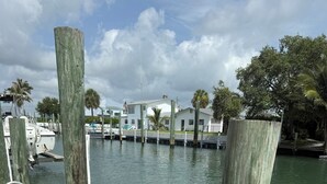 A wooden dock leading to a marina with boats and houses in the background. - Charming 3-bedroom townhome with a river view and a 40 boat slip in Fort Pierce (Fort Pierce)