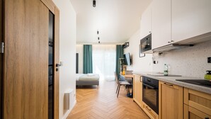 Une cuisine moderne avec des meubles en bois, un four encastré et un plan de travail.