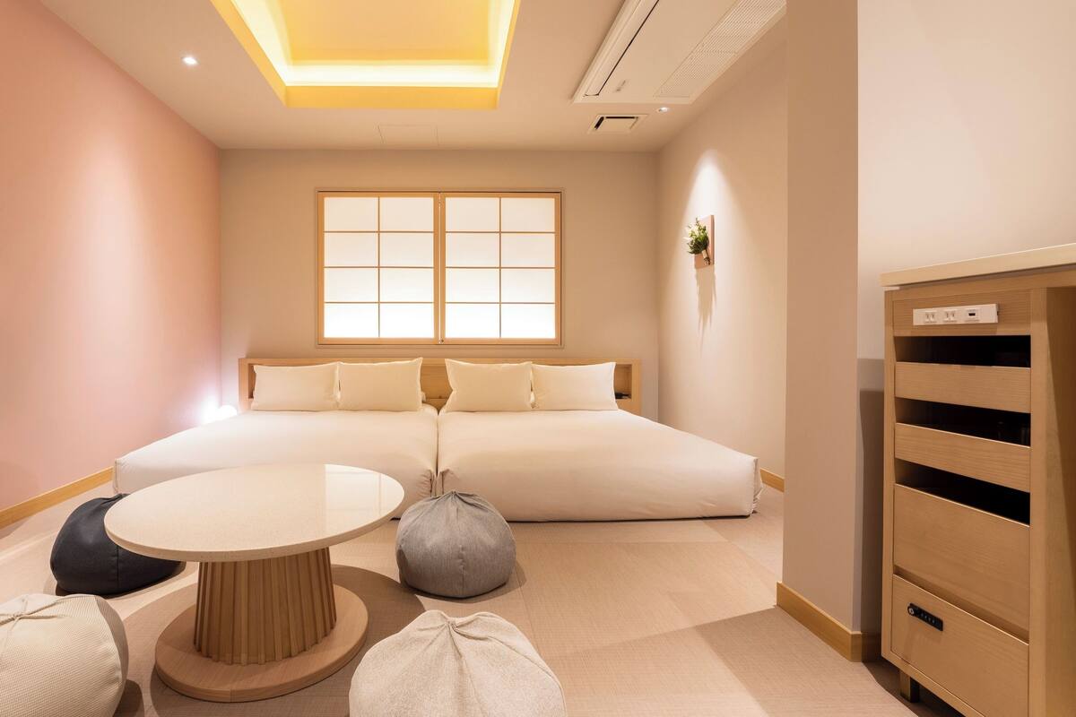 A modern bedroom with a bed, a TV, a table, and a cabinet.
