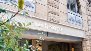 A hotel facade with a stone exterior, a clear sign reading "hotel hisoca," and a modern entrance with glass doors. - hotel hisoca ikebukuro (Tokyo)