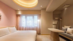 A modern hotel room with a large bed, a round table, a sofa, and a large window with sheer curtains. - hotel hisoca ikebukuro (Tokyo)