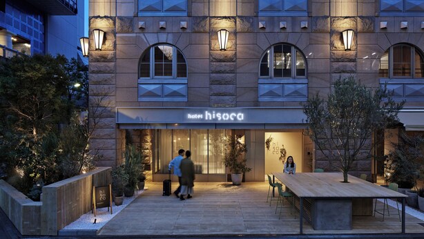 A hotel entrance with a modern facade, a wooden deck, and outdoor seating. - hotel hisoca ikebukuro (Tokyo)