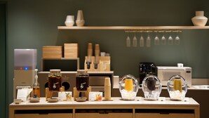 A beverage station with various drinks and containers, including bottles, glasses, and a coffee machine. - hotel hisoca ikebukuro (Tokyo)