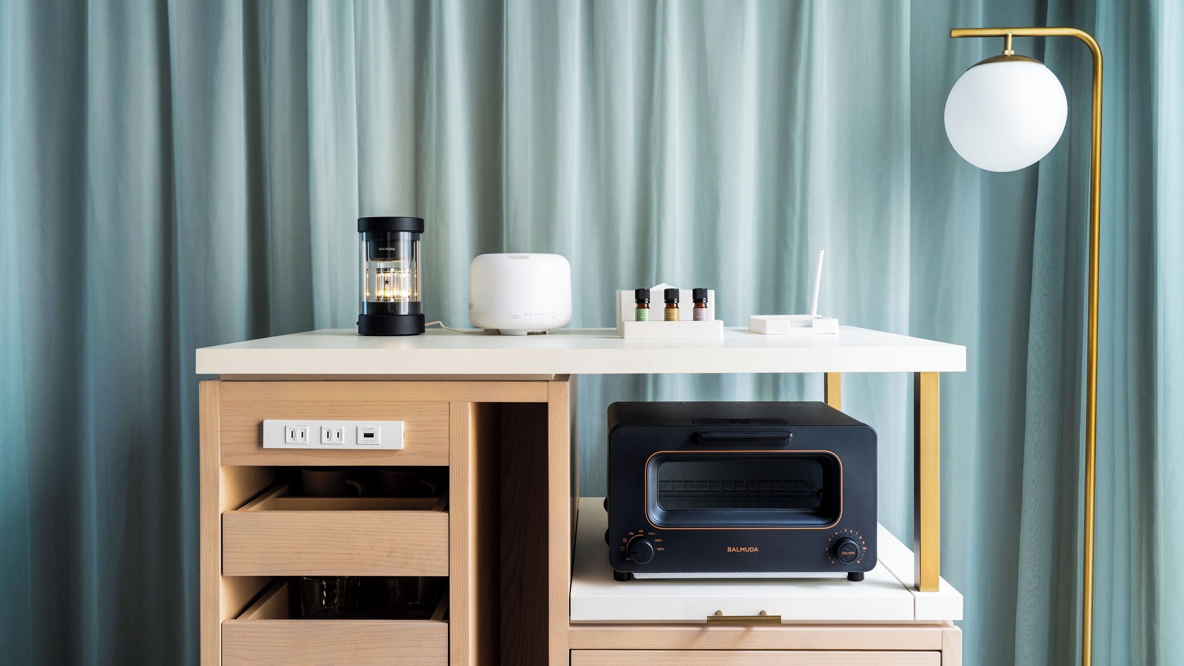 A modern kitchen with a coffee maker, a toaster, and a kettle on a white countertop.