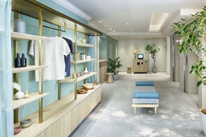 A modern bathroom with a vanity, shelves with toiletries, a bench, and a potted plant. - hotel hisoca ikebukuro (Tokyo)