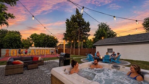 Un espacio al aire libre con jacuzzi, asientos y una cancha de baloncesto.
