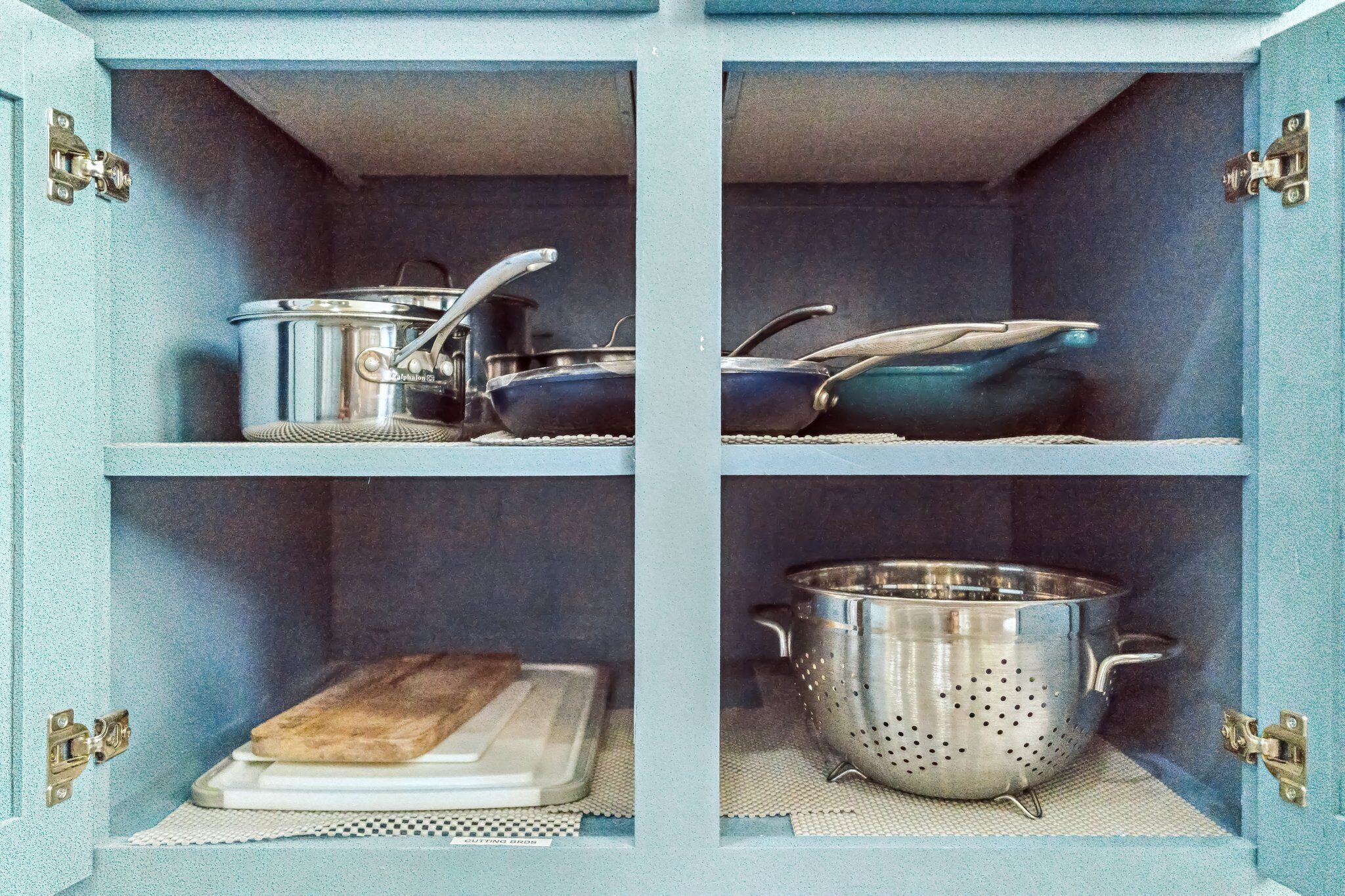 Un meuble de cuisine doté de quatre étagères, chacune contenant des ustensiles de cuisine.