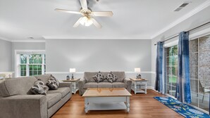 A living room with a grey sofa, a wooden coffee table, and a ceiling fan. - MN 4872-101 | Beautiful Myrtlewood Golf Villa | Myrtle Beach (Myrtle Beach)