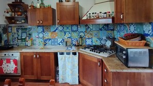 A kitchen with wooden cabinets, a tiled backsplash, a gas stove, and a vintage toaster. - In the countryside, a cozy retreat for peaceful moments near Mount Vesuvius. (Torre del Greco)
