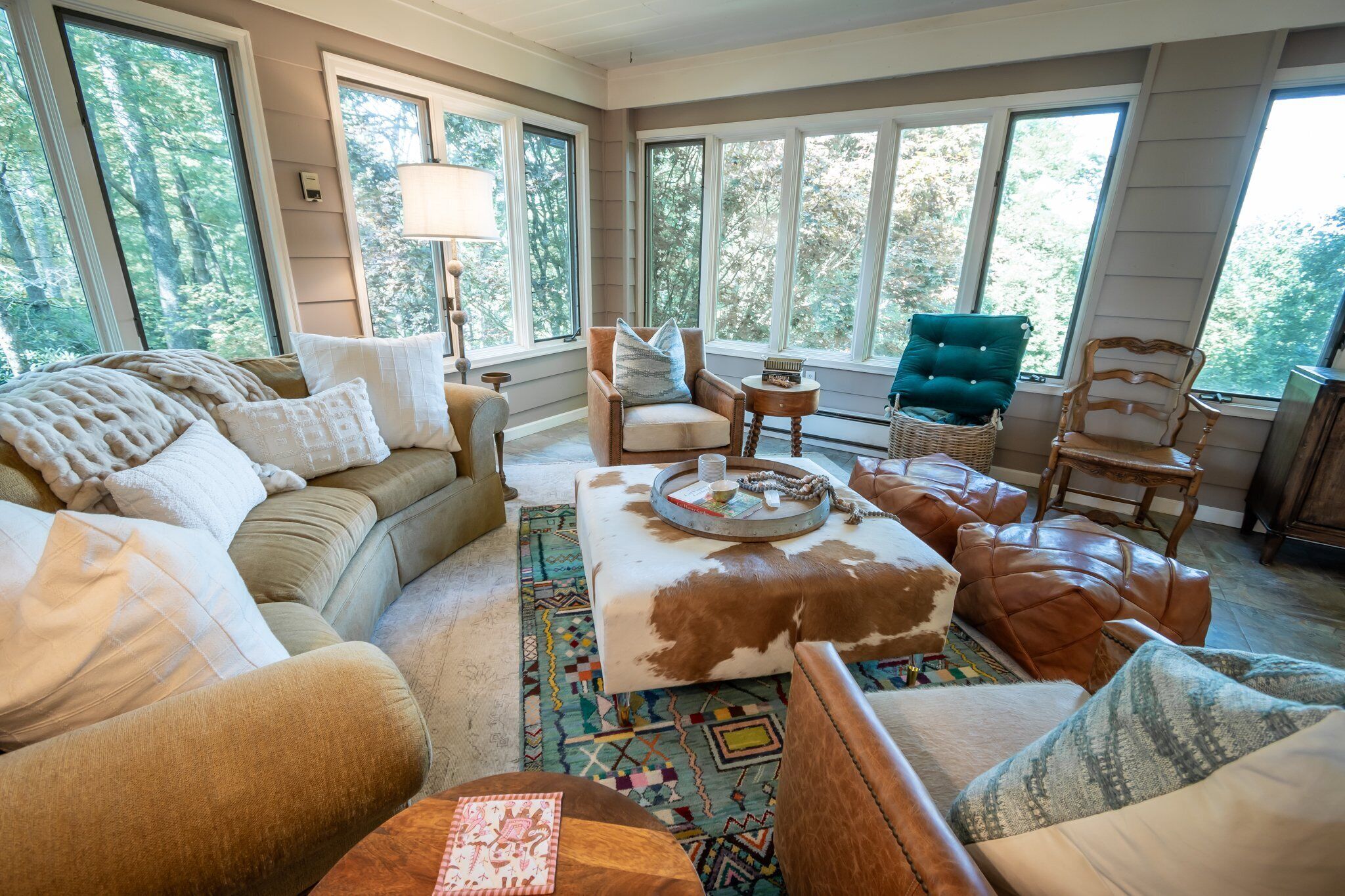 A cozy living room with a sofa, armchairs, a coffee table, and a patterned rug.
