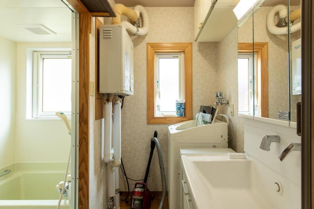 A bathroom with a bathtub, a sink, and a window.