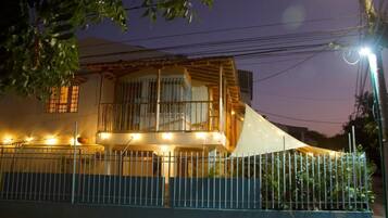 A two-story house with a balcony, a fence, and a streetlight.