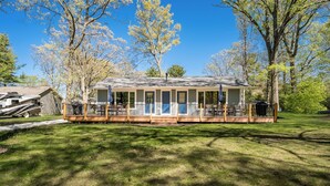 A single-story house with a porch, a deck, and a covered outdoor seating area. - Awesome Silver Lake Rental - Short Distance to Lake MI (Mears)