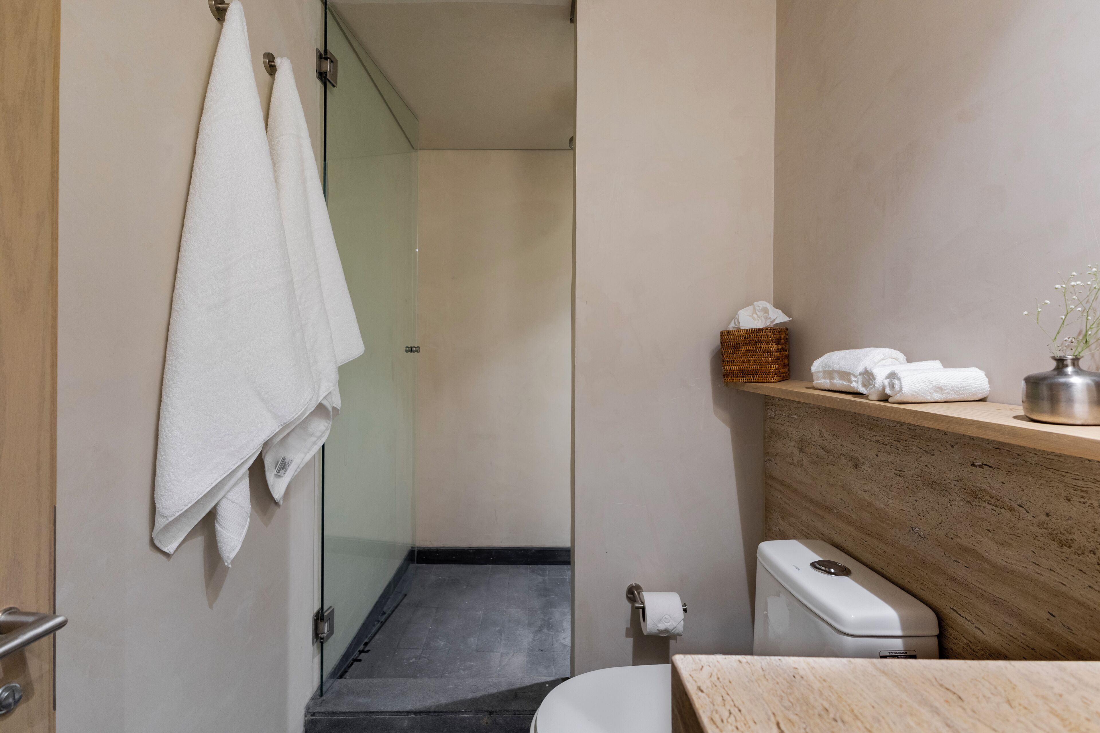 Ein Badezimmer mit Toilette, Waschbecken, Spiegel und Handtuchhalter mit Handtüchern.