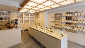 A modern hotel lobby with a central reception desk, shelves with toiletries, and a large mirror. - Lamartine  (Mexico City)