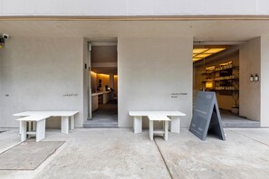 A modern building exterior with two white tables and a black signboard. - Lamartine  (Mexico City)
