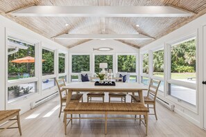 Un comedor espacioso con techo alto, ventanas grandes y vistas al exterior.
