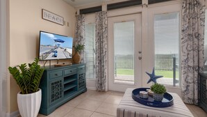 Ein Wohnzimmer mit Fernseher, Topfpflanze, blauem Tablett und einer Stern-Dekoration.
