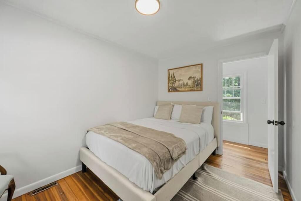 A bedroom with a bed, a door, and a window.