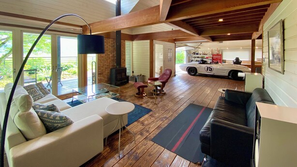 A spacious living area with a high ceiling, a fireplace, and a classic car in the background. - GARDEN SHED (Yamanakako)