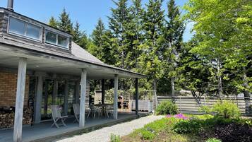 A house with a covered porch, outdoor seating, and a garden.