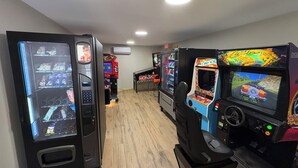 Eine Reihe von Spielautomaten in einem Raum mit Holzboden und eingelassener Deckenbeleuchtung.
