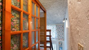 Una escalera de madera con papel tapiz estampado y techo con textura.