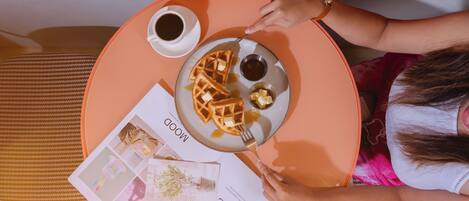 A table with waffles, syrup, and a magazine titled "Love Life".