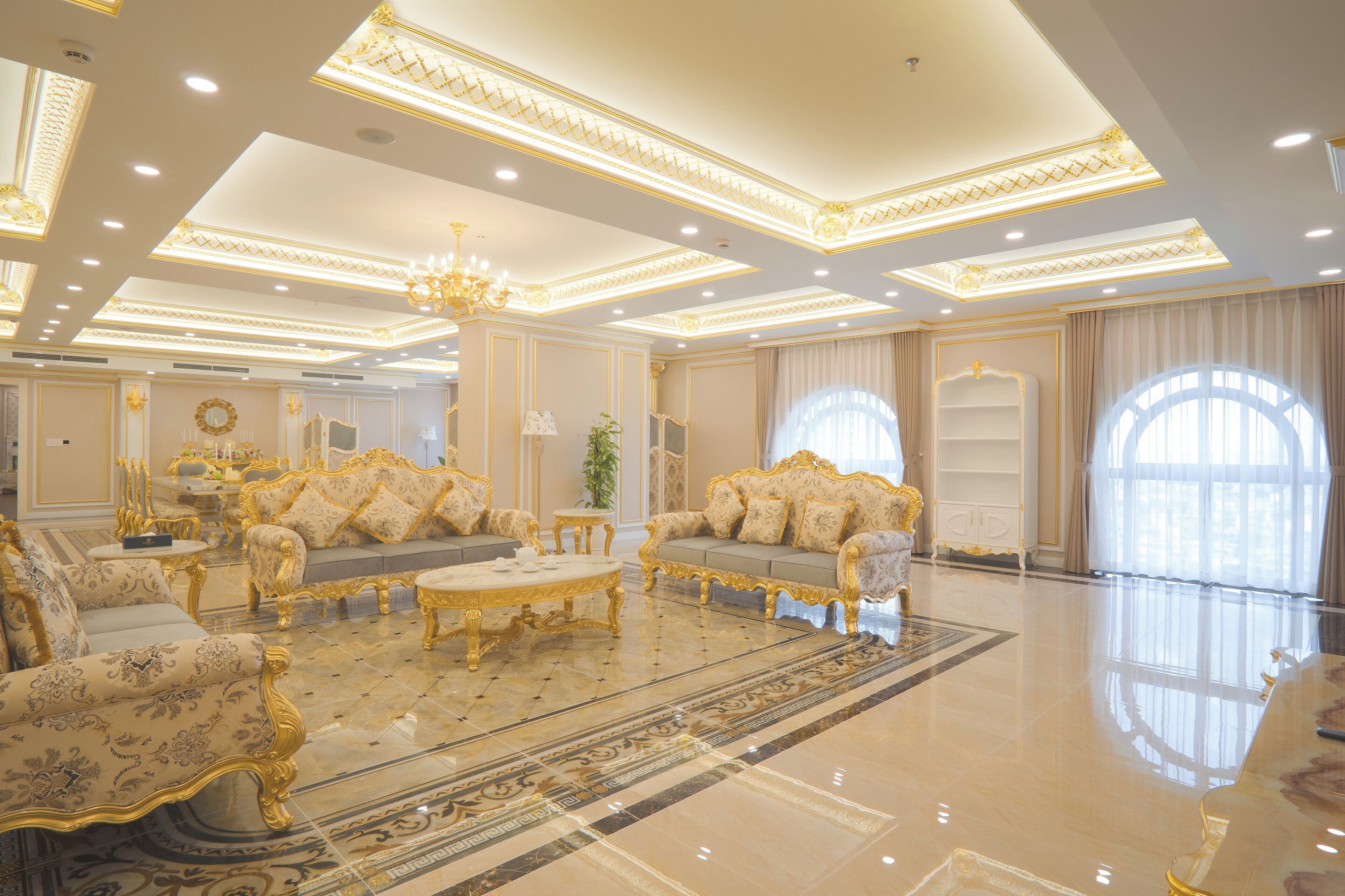 A luxurious room with ornate furniture, a chandelier, and large windows.