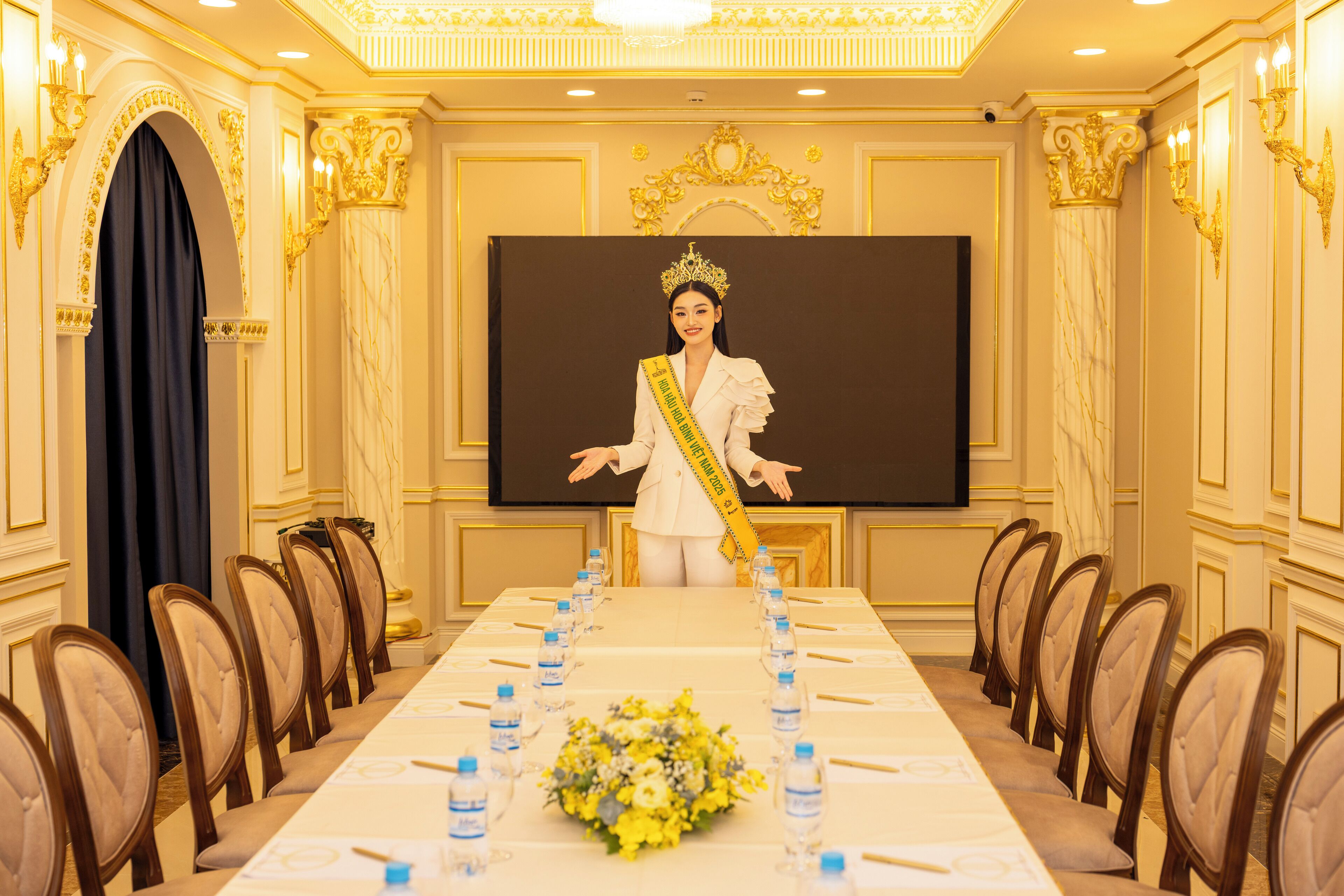 A conference room with a long table, chairs, a podium, and a screen.