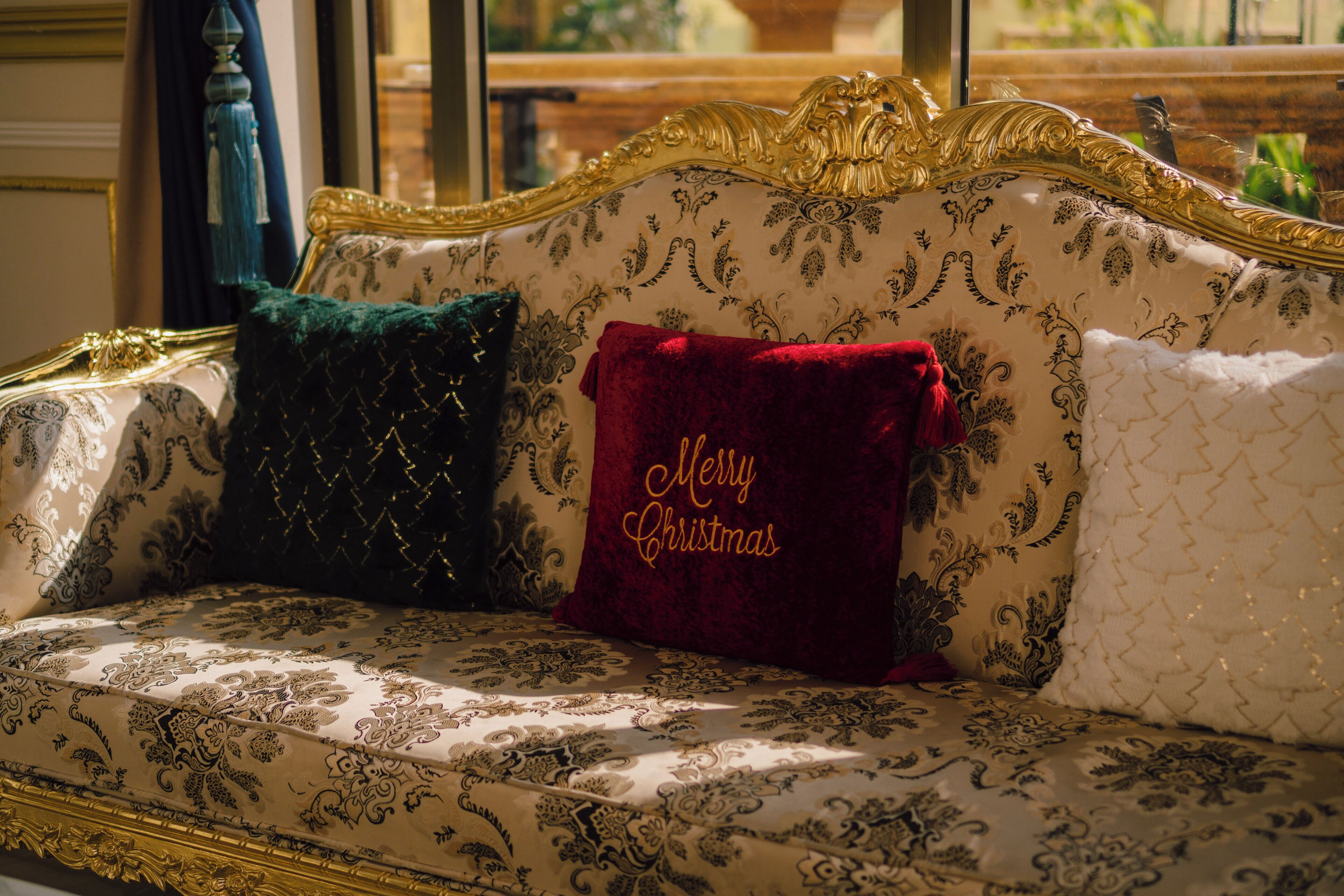 A luxurious sofa with ornate gold detailing and patterned upholstery.