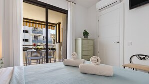 A hotel room with a bed, a desk, a chair, a dresser, and a TV. - Montemar Puerto - Beachfront, Terrace, Swimming Pool. Sea Views (Torremolinos)