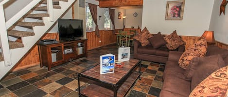 A living room with a staircase, a television, a sofa, and a coffee table.