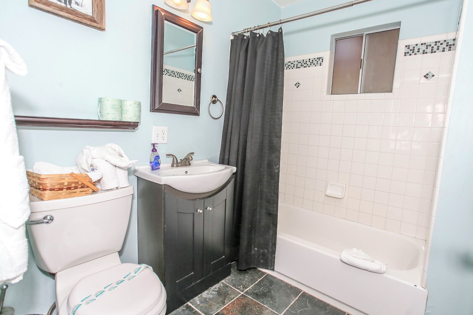A bathroom with a toilet, sink, and bathtub.