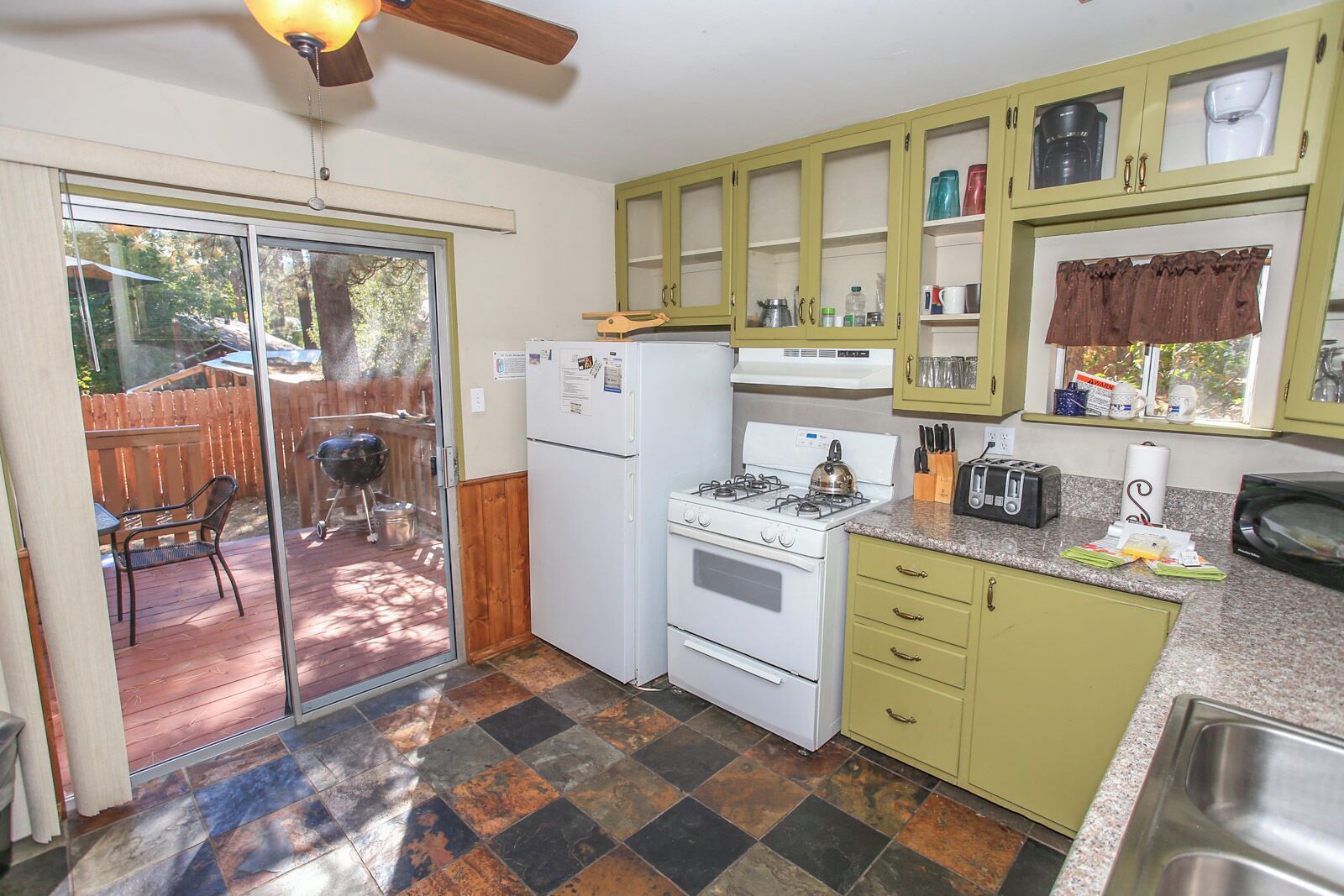 A compact kitchen with a refrigerator, stove, and a small countertop.