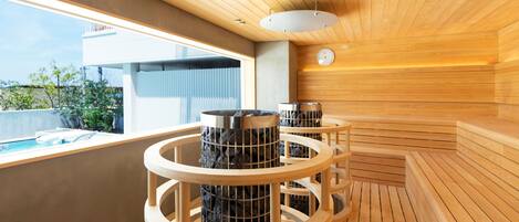 A modern sauna with wooden benches and a circular design, a visible clock, and a view of the outside.