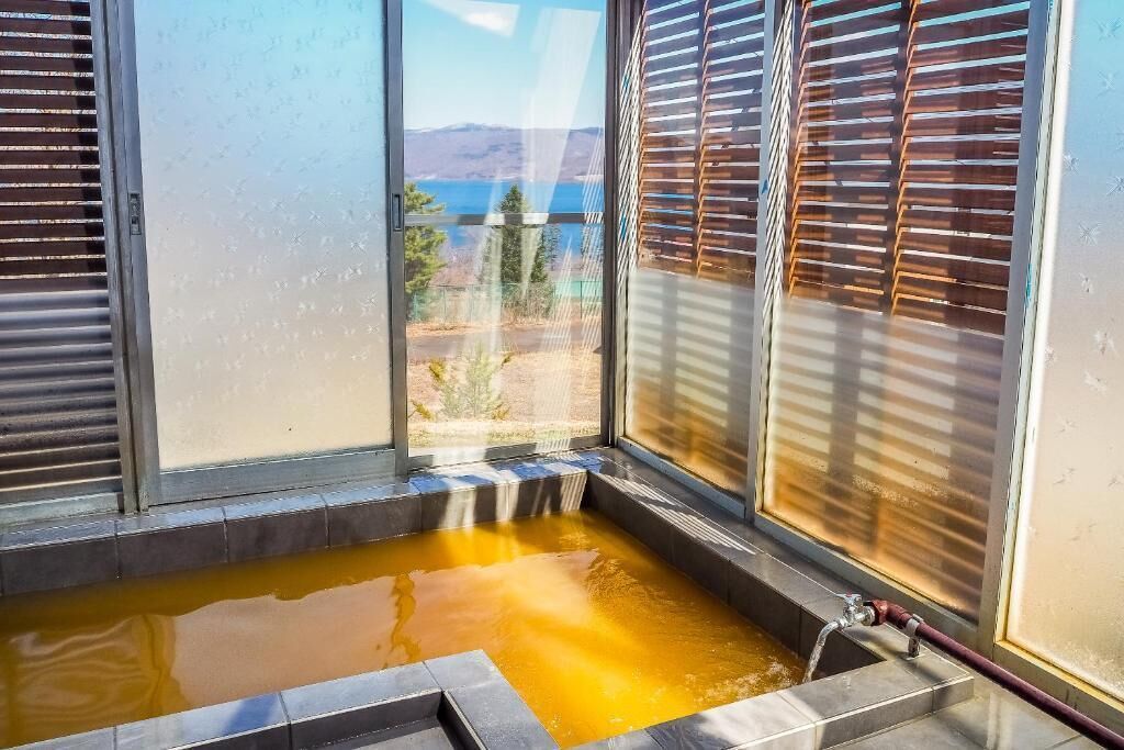 A hot tub with a view of a lake and mountains.