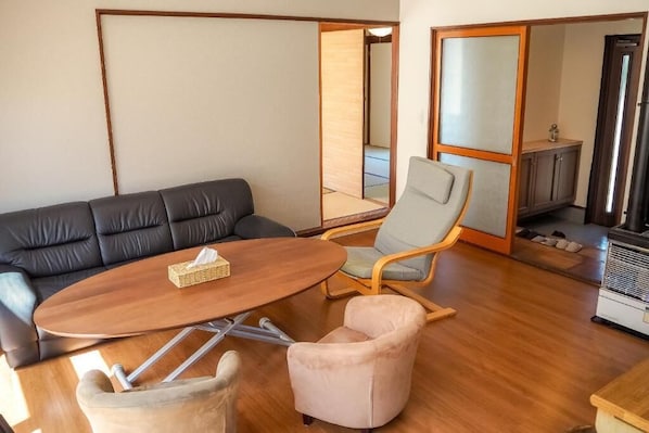 A living room with a sofa, a round table, a chair, and a cabinet. - TOYA ONSEN VILLA (Usu-gun, Sobetsu-cho, Sobetsu ONSEN)