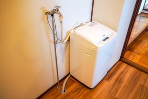 A water heater with a control panel, connected to a wall-mounted faucet and a flexible hose. - TOYA ONSEN VILLA (Usu-gun, Sobetsu-cho, Sobetsu ONSEN)