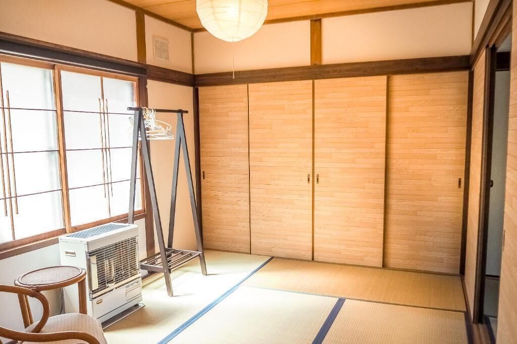 A traditional Japanese room with tatami flooring, a sliding door, a heater, and a ladder.