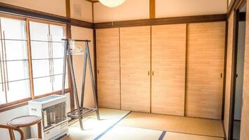 A traditional Japanese room with tatami flooring, a sliding door, a heater, and a ladder.